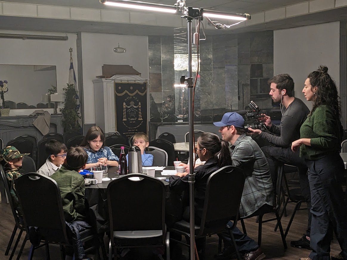 Wide behind-the-scenes view of students and crew on set