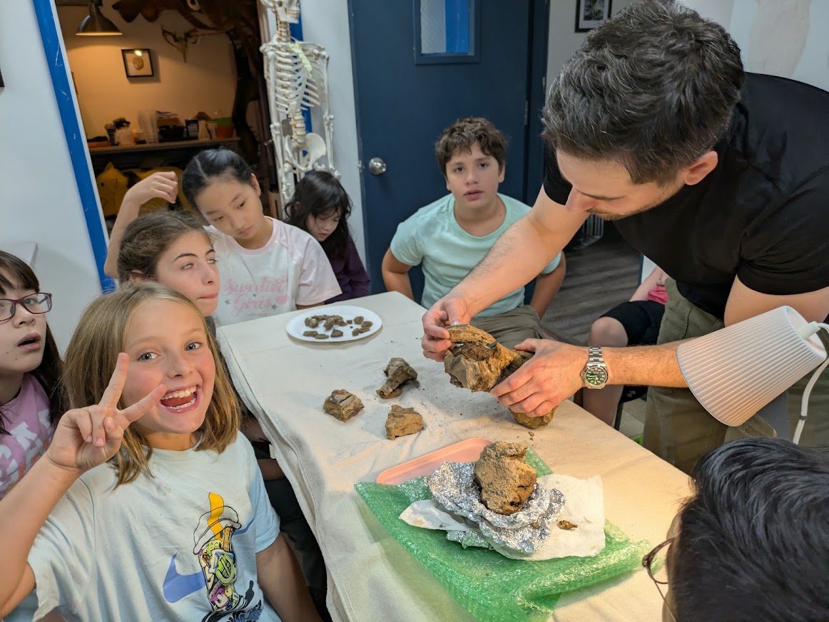 Students gathered around fossil material during preparation
