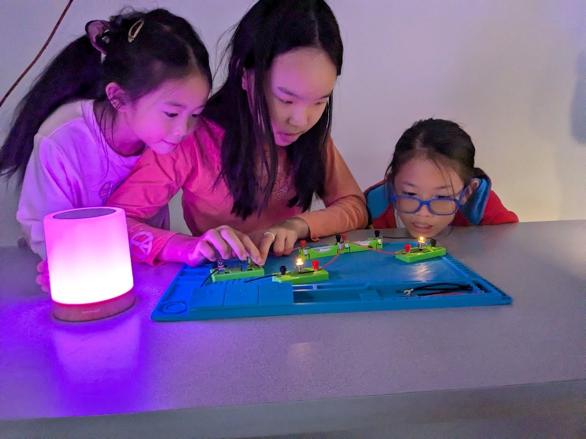Students building illuminated electrical circuits