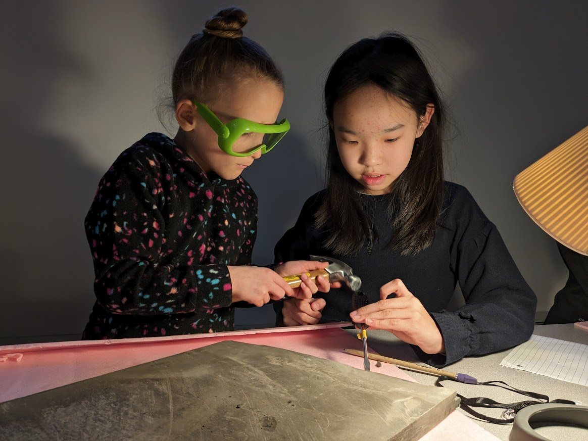 Students using goggles and hand tools during fossil preparation